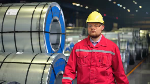 Handsome Engineer Walking in a Factory alt