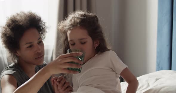 Mom Giving Water to Sick Daughter alt