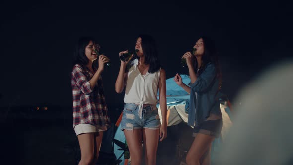 Group of Asia best friends dancing and drinking have fun salute toast of bottle beer at night.