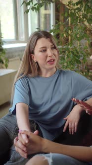 LGBT Women Sit Together in the Living Room Talk to Each Other Holding Hands alt