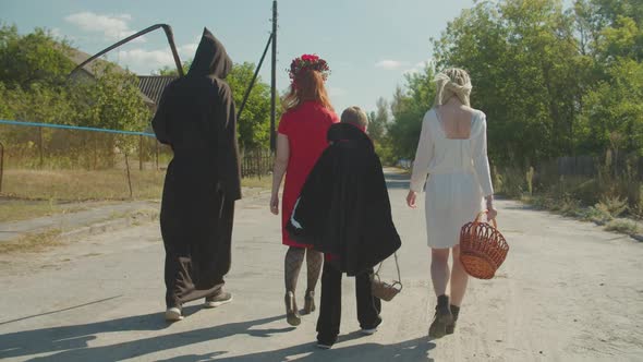 People in Costumes Celebrating Halloween in Village alt