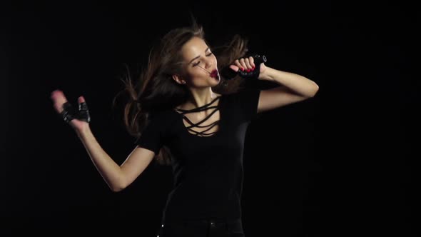 Singer at Her Concert Performs Driving Songs and Energetically Dances. Black Background. Slow Motion alt