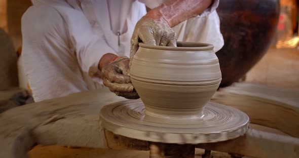 Skilled Hands of Potter Shaping the Clay on Potter Wheel and Sculpting Clay Pot Jar. Shilpagram alt
