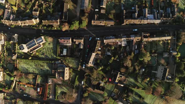 Aerial drone video of a Cotswolds Village, a rural scene in English countryside with houses, propert alt