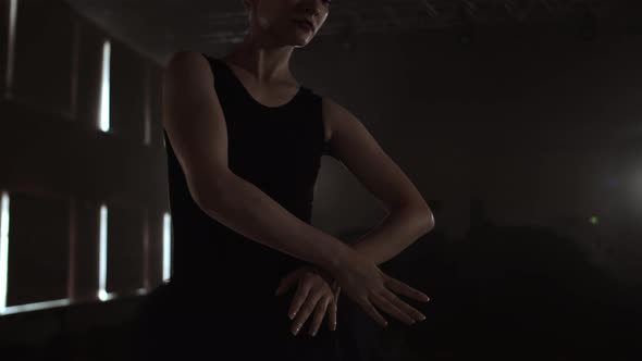 Closeup of Ballet Dancer As She Practices Exercises on Dark Stage or Studio alt