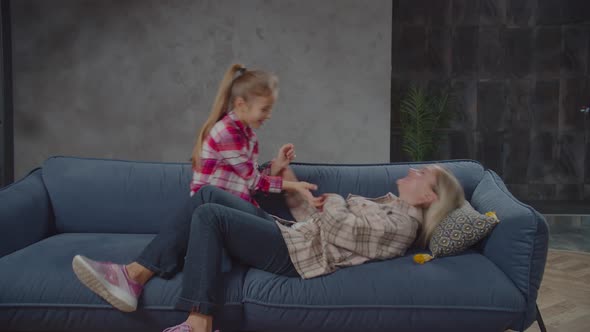 Carefree Preadolescent Girl and Mom Having Fun on Couch, Stock Footage 