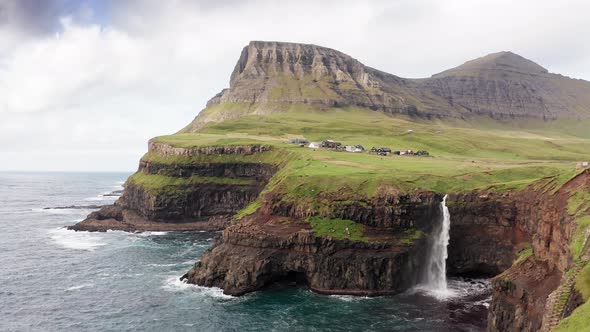 Stunning Waterfall Splashing From Cliff Aerial View. Mulafossur Waterfall Near Gasadalur Village at alt