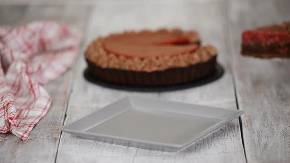 Piece of delicious chocolate tart with cherry confit and chocolate cream alt