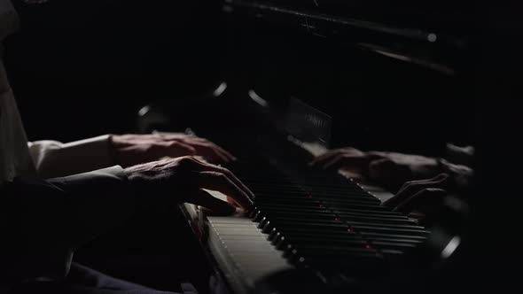 Male Hands Plays Fast Cheerful Music on Piano on Black Background alt