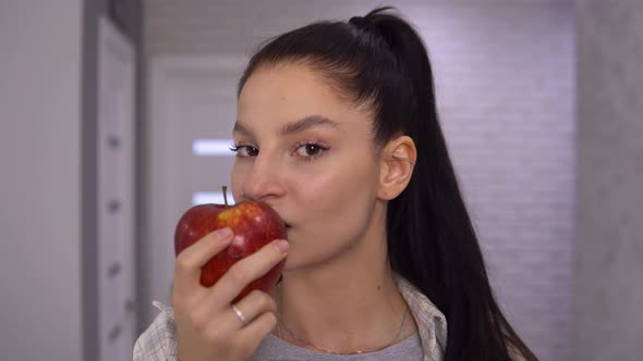 Happy Woman Biting Big Red Apple and Say YAMMY Looking at Camera