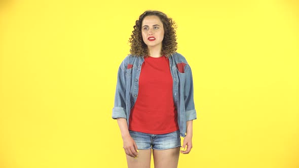 Curly Female Feels Very Bad, Her Stomach Hurts on Yellow Background at Studio alt