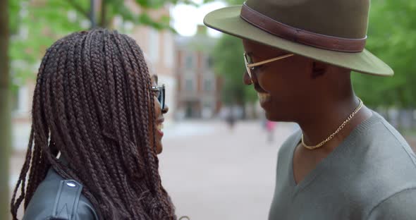 Close Up of African Young Man and Woman Holding Hands and Talking Outdoors alt