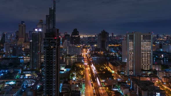 Bangkok traffic toward downtown on Taksin bridge at night, tilt up - time lapse