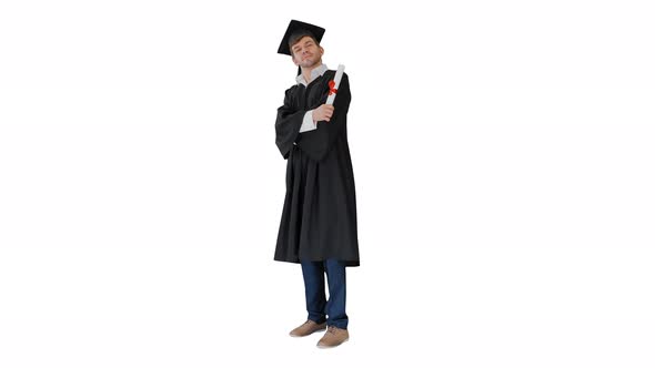 Happy Male Student in Graduation Robe Posing and Waiving with His Diploma on White Background alt