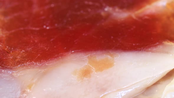 Air dried ham slices rotating, macro shot. alt