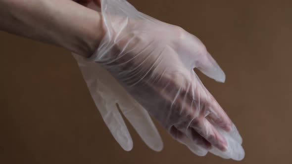 Female hands wear transparent protective gloves