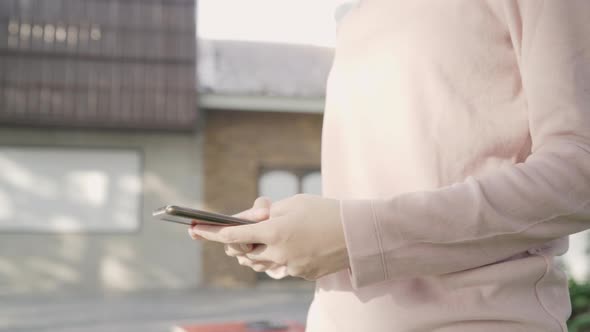 Asian tourist blogger woman using touchscreen technology at smartphone while walking. alt