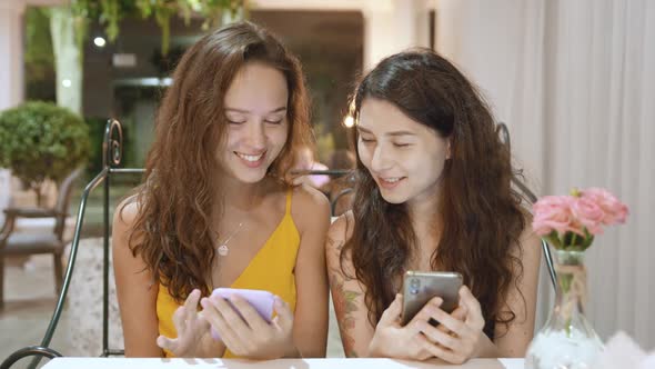 Beautiful Young Women Using Smartphone in Cafe Texting Sharing Messages on Social Media Enjoying alt