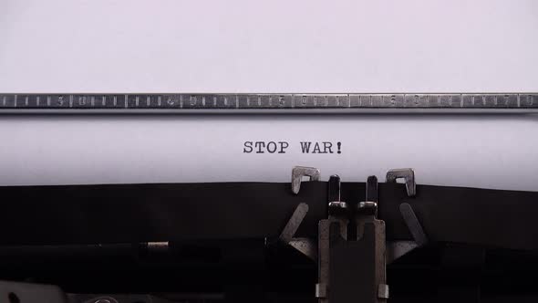 Typing phrase "STOP WAR !" on retro typewriter. alt