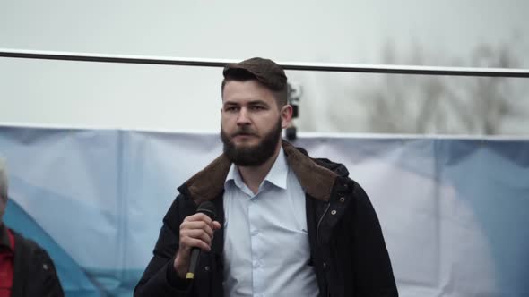 Annoyed Spokesman Guy on Stage with Mic Gives Speech and Address Riot Activism alt