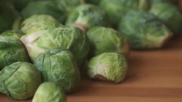 Slow Panning Right to Left on Heap of Raw Brussels Sprouts on Wooden Tabletop alt