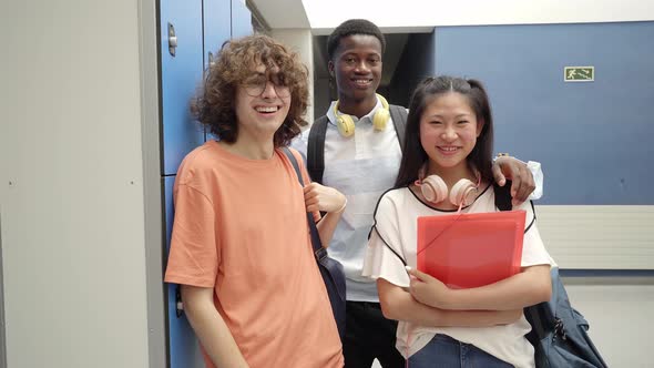 Portrait of Three Multiracial Students Looking at the Camera Smiling at a High School alt