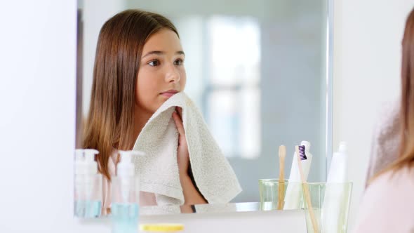 Teenage Girl Wiping Face with Towel at Bathroom alt