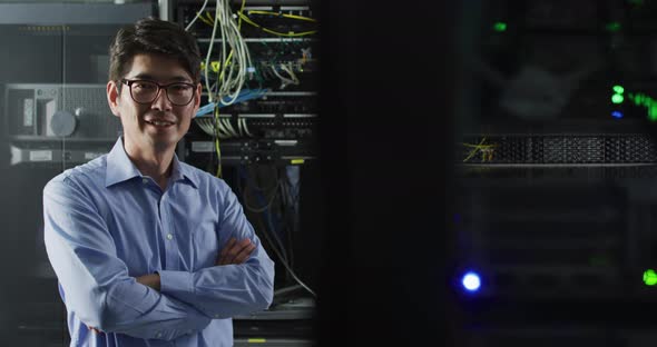 Portrait of smiling asian male it technician by computer server alt