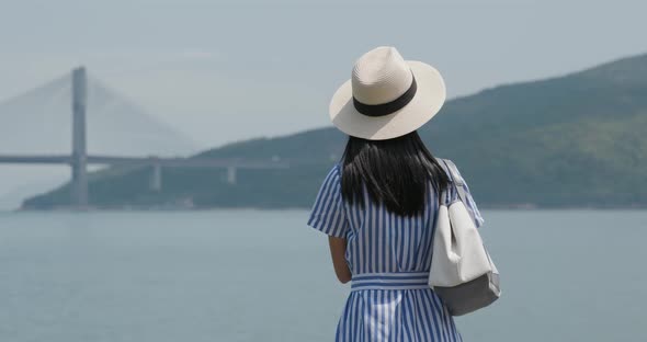 Woman look at the sea with straw hat