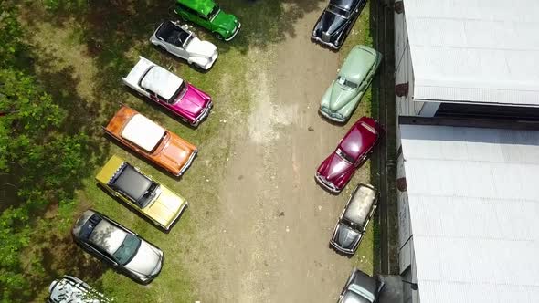 Colorful Collection of Antique Vintage Classic Cars Overhead Tilt Up Drone Shot alt