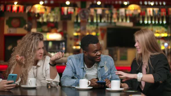 Happy Diverse Mates Having Fun with Gadget Together Watching Funny Online Video on Smartphone alt