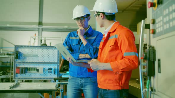Male Asian engineer professional  having a discussion standing consult cnc machine alt