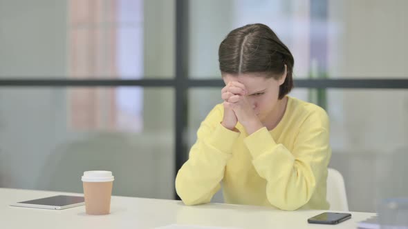 Upset Young Woman Feeling Worried While Sitting in Office alt
