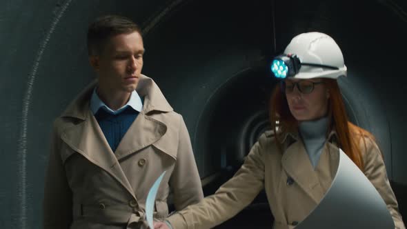 Businesswoman discussing plan of a tunnel with a man alt
