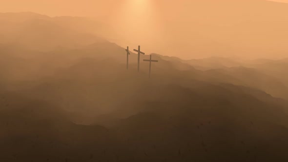 Atmospheric, dark image of three crosses silhouetted on the top of a mountain. alt