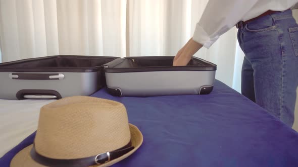 a woman in a Santa Claus hat puts things out of a suitcase after a vacation alt