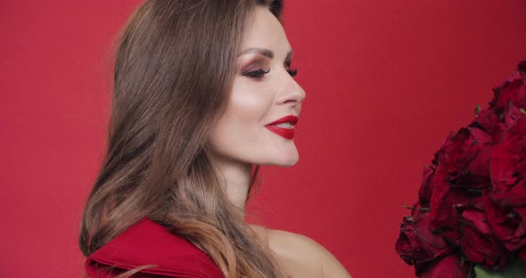 Gorgeous Woman in Red Dress Spinning with Bouquet of Roses