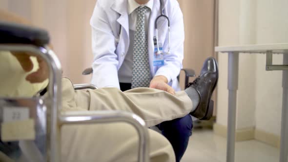 Orthopedist examines the knee of elderly patient to collect information for physical therapy treated alt