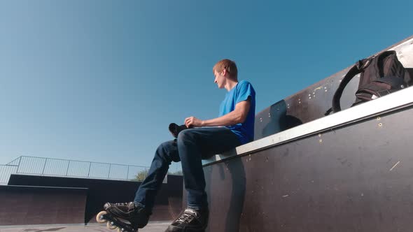 Man In Skate Park Putting On Protection alt