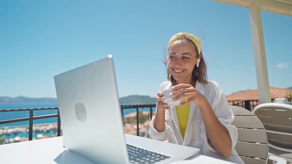 Attractive Mixed Rase Woman Enjoying Morning Coffee While Sitting on Terrace with Sea View on alt