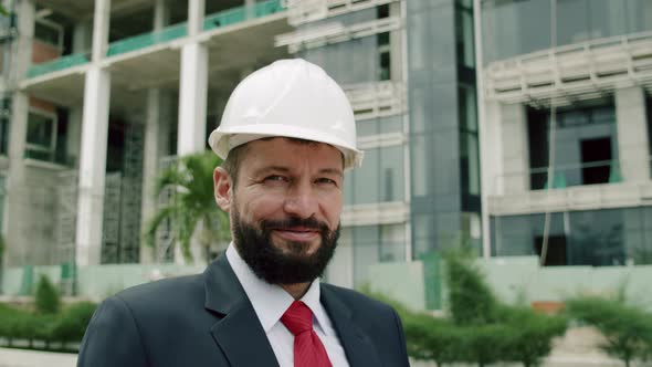 Potrait Senior Engineer Planning Manufacture Work in a Business Suit in a White Protective Helmet alt