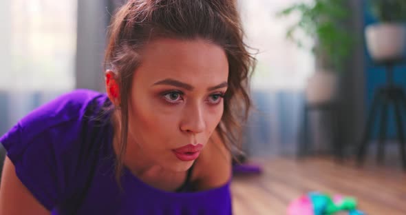 Portrait of Young Beautiful Athletic Girl in Leggings and Top Makes an Exercise Plank alt