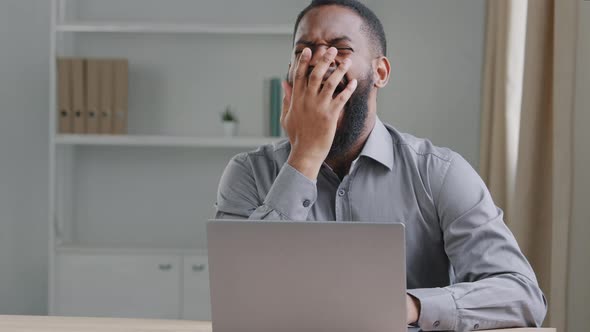 Tired Young African Mixed Race Male Worker Yawning Taking Nap at Table alt