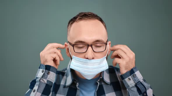 Closeup Portrait of Guy Putting on Face Medical Protective Mask Isolated alt