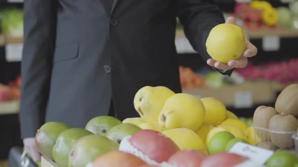Unrecognizable Young Caucasian Man Selecting Yellow Pears in Grocery. Male Vegan Choosing Fruit From alt