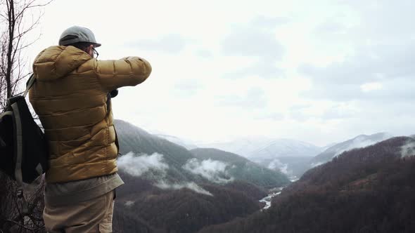 Photographer Is Taking Pictures of Dramatic River Valley, Stand on a Hilltop alt