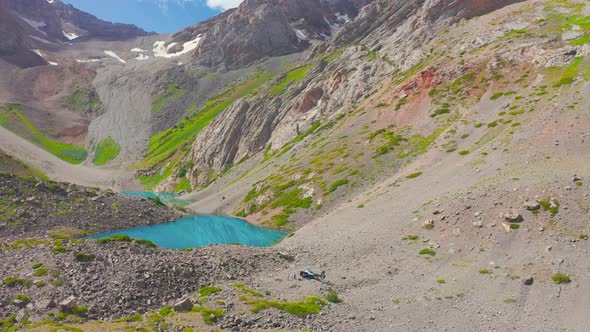 A Group of Tourists By a Helicopter Near a Lake in the Mountains of Kazakhstan alt