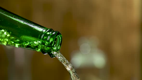 Stream of Cold Fresh Beer Pours From a Green Misted Bottle alt