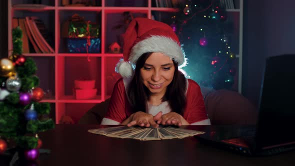 Young Woman in Santa Costume with Dollar Bills in Office alt