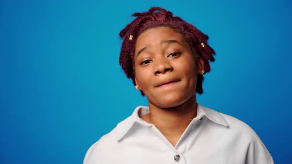 Happy Young Afro American Woman Dancing in Studio Against Blue Background